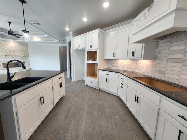 701 Eagle Claw Dr, Salado, TX 76571 - kitchen with dark countertops, a sink, decorative backsplash, custom exhaust hood, and ceiling fan