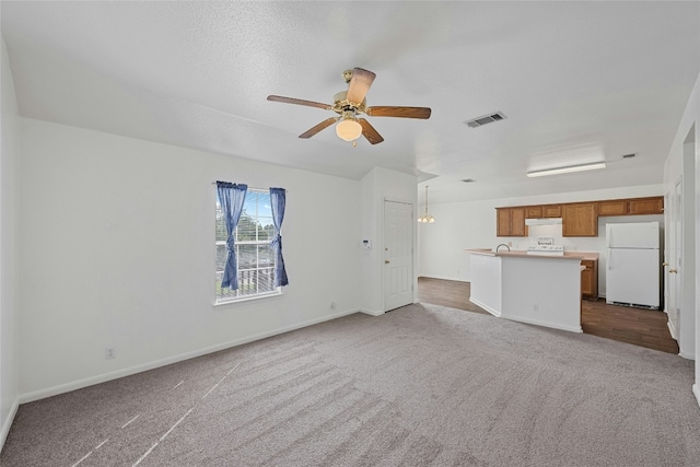 3201 El Salido Pkwy Bldg E, Cedar Park, TX 78613 - unfurnished living room featuring dark carpet, visible vents, a ceiling fan, and baseboards