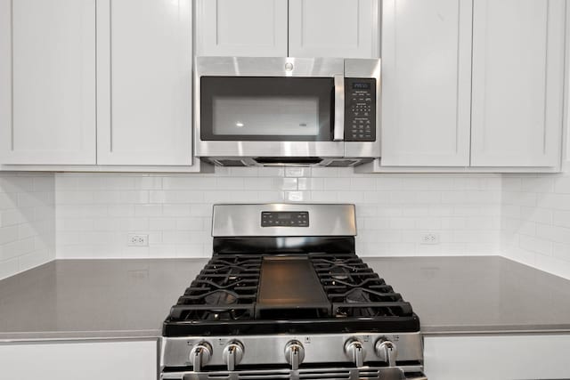 110 Madrid, Kyle, TX 78640 - kitchen featuring stainless steel appliances, decorative backsplash, and white cabinetry