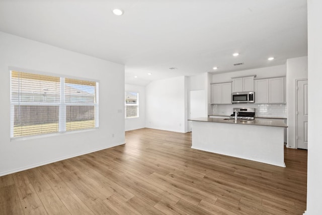 110 Madrid, Kyle, TX 78640 - kitchen with appliances with stainless steel finishes, tasteful backsplash, light wood-style floors, recessed lighting, and open floor plan