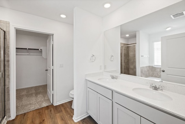 110 Madrid, Kyle, TX 78640 - full bathroom with a stall shower, a spacious closet, toilet, wood finished floors, and recessed lighting