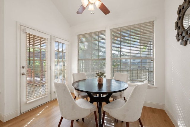 dining room with vaulted ceiling, light wood-type flooring, a ceiling fan, and baseboards