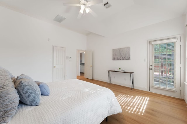 bedroom featuring light wood finished floors, baseboards, visible vents, and access to outside