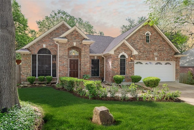 view of front of property featuring brick siding, a front lawn, driveway, and roof with shingles