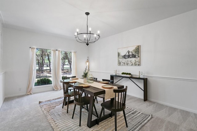 dining space featuring baseboards, a notable chandelier, and carpet flooring