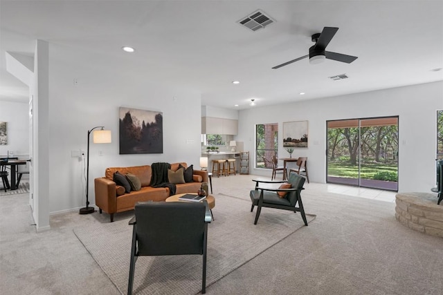 living area featuring light carpet, a ceiling fan, visible vents, and recessed lighting