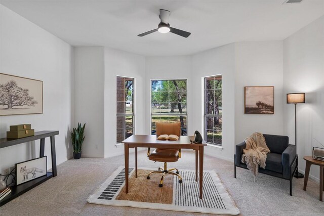 carpeted office space featuring visible vents and a ceiling fan