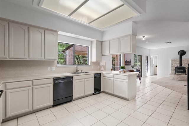 kitchen featuring light countertops, dishwasher, a sink, a peninsula, and open floor plan