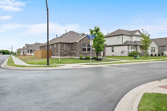view of street with a residential view, curbs, sidewalks, and street lights