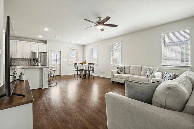 living room featuring recessed lighting, a ceiling fan, baseboards, and dark wood-style flooring