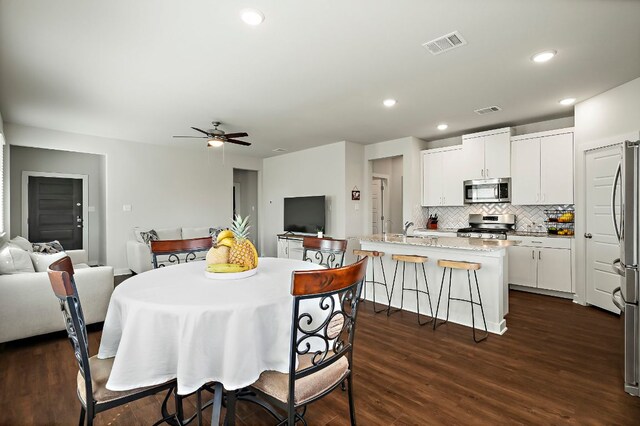 dining room with dark wood-style floors, ceiling fan, visible vents, and recessed lighting