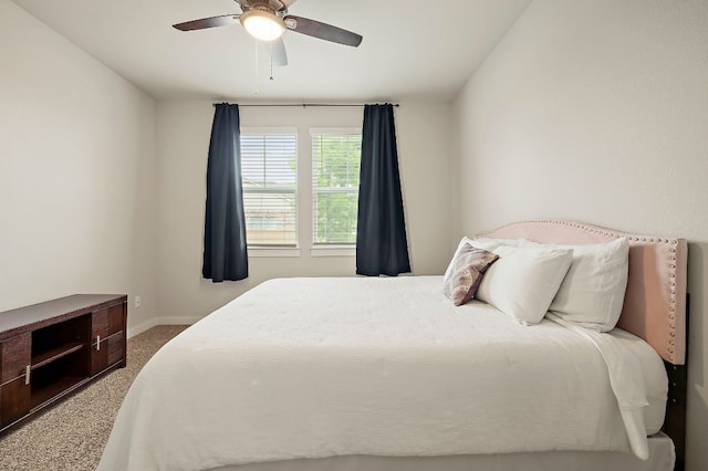 carpeted bedroom with ceiling fan and baseboards