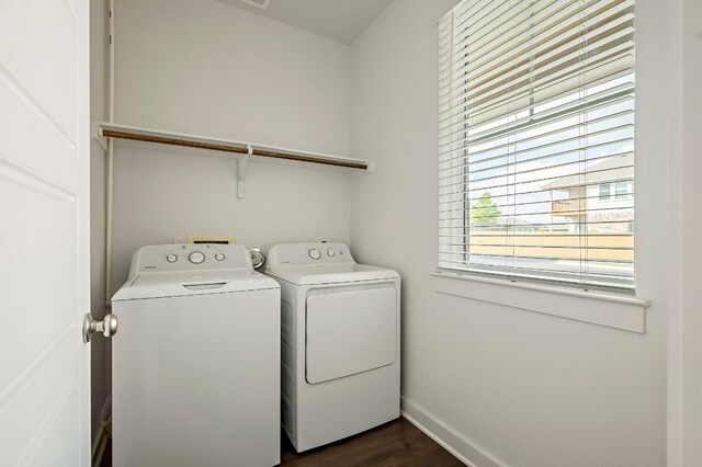 washroom featuring dark wood-type flooring, baseboards, washer and dryer, and laundry area