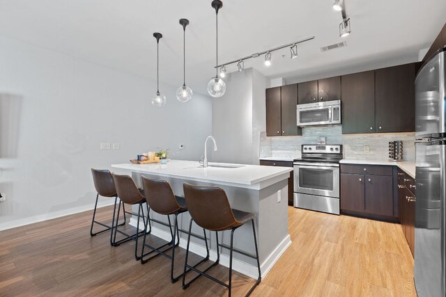 1900 Barton Springs Rd Unit 3007, Austin, TX 78704 - kitchen with stainless steel appliances, a sink, light wood finished floors, light countertops, and tasteful backsplash