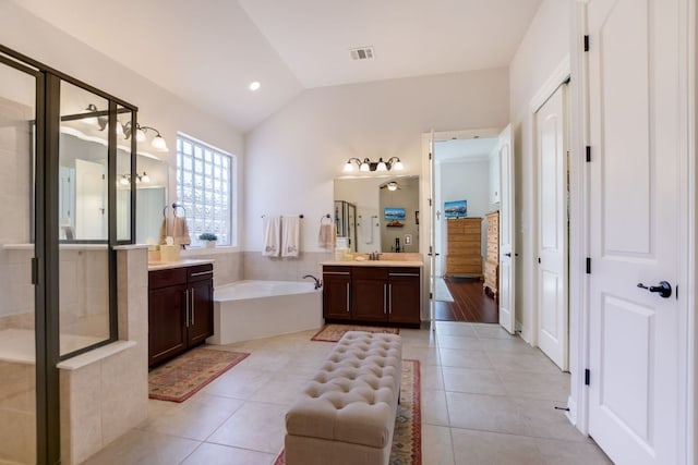 300 Horseback Holw, Austin, TX 78732 - full bathroom featuring a garden tub, two vanities, tile patterned floors, and vaulted ceiling