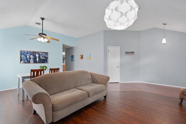 living area featuring baseboards, visible vents, lofted ceiling, wood finished floors, and ceiling fan