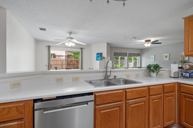 kitchen with a sink, a textured ceiling, visible vents, a ceiling fan, and dishwasher