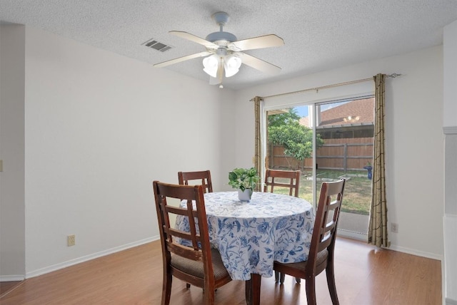 2300 Rick Whinery Dr, Austin, TX 78728 - dining area featuring wood finished floors, a ceiling fan, a textured ceiling, and baseboards