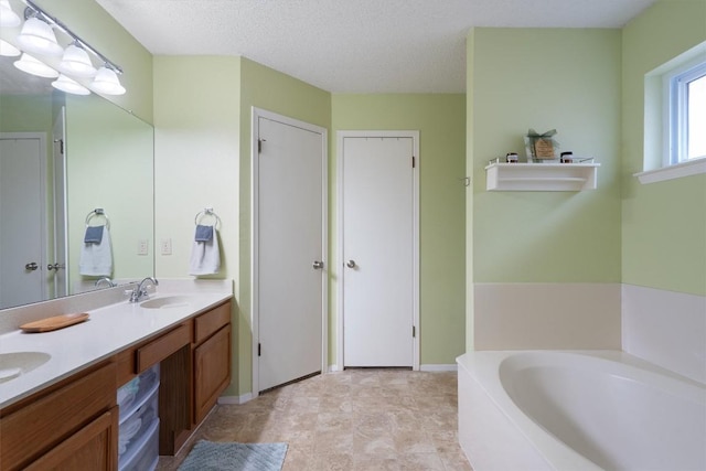 bathroom with double vanity, a bath, and a sink
