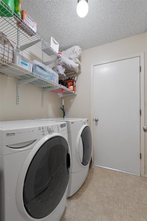 laundry room with light floors, a textured ceiling, independent washer and dryer, and laundry area
