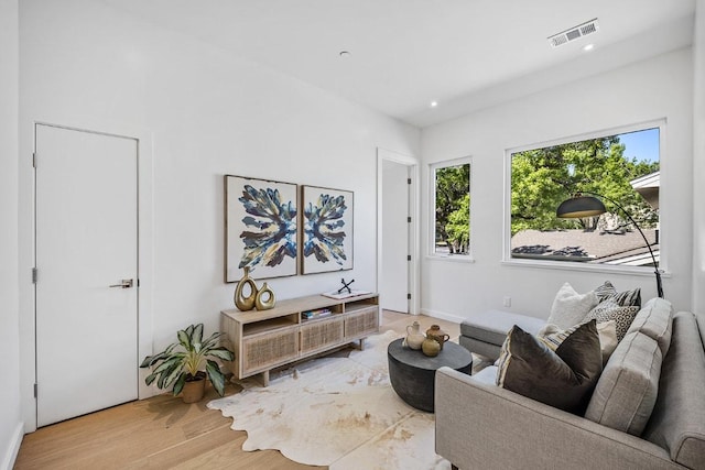 living area with recessed lighting, wood finished floors, visible vents, and plenty of natural light