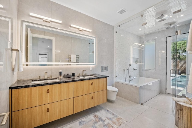 full bathroom with double vanity, a shower with shower door, a bathing tub, and a sink