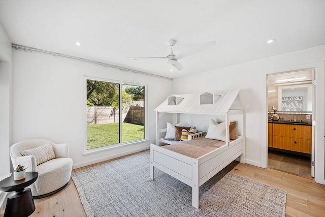 bedroom featuring recessed lighting, a ceiling fan, ensuite bathroom, and light wood-style flooring
