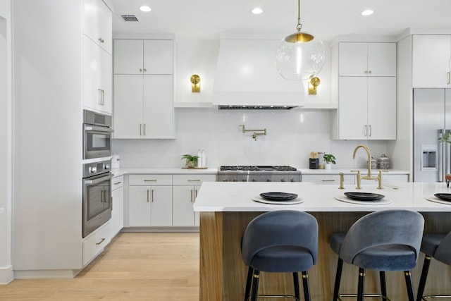 kitchen with custom range hood, light countertops, and a sink