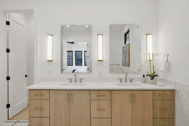 bathroom featuring double vanity, a ceiling fan, and a sink