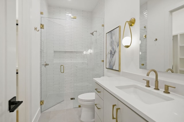 bathroom with toilet, tile patterned flooring, a shower stall, and vanity