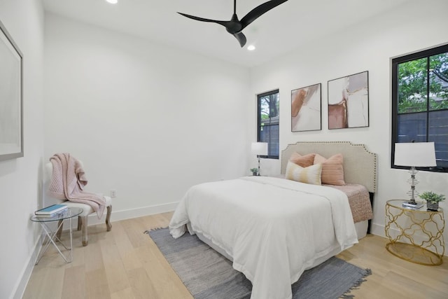 bedroom featuring recessed lighting, wood finished floors, and multiple windows