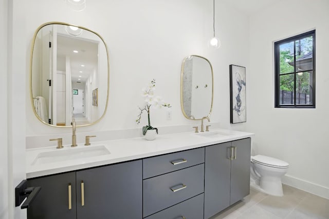 full bath with tile patterned floors, toilet, double vanity, and a sink