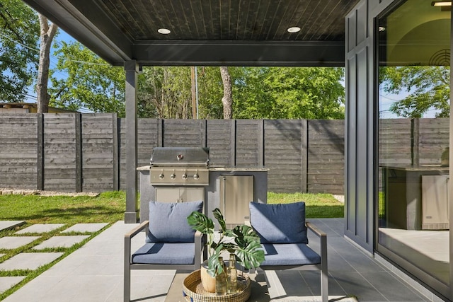 view of patio with grilling area and a fenced backyard