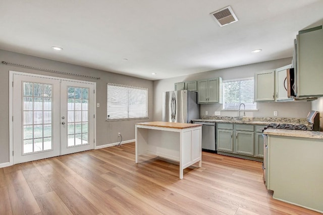 6603 Krollton Dr, Austin, TX 78745 - kitchen featuring appliances with stainless steel finishes, light wood finished floors, french doors, recessed lighting, and baseboards