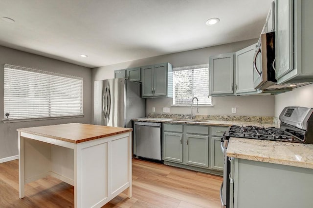 6603 Krollton Dr, Austin, TX 78745 - kitchen with appliances with stainless steel finishes, a sink, light wood-style floors, wood counters, and open shelves