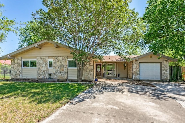 ranch-style house with a front lawn, driveway, stone siding, fence, and an attached garage