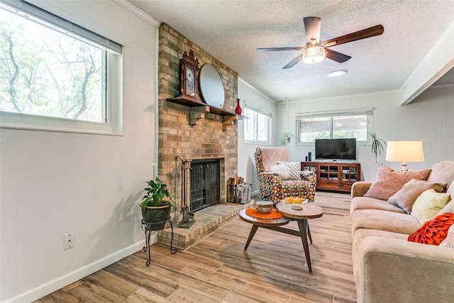 living room with ornamental molding, wood finished floors, a textured ceiling, and a fireplace