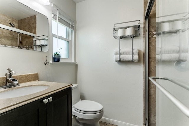 full bathroom with a shower stall, toilet, vanity, and baseboards