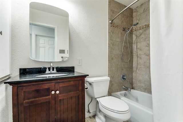 bathroom with a textured wall, shower / tub combo with curtain, vanity, and toilet