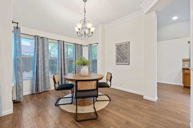 8104 Isaac Pryor Dr, Austin, TX 78749 - dining space featuring vaulted ceiling, crown molding, wood finished floors, baseboards, and a notable chandelier