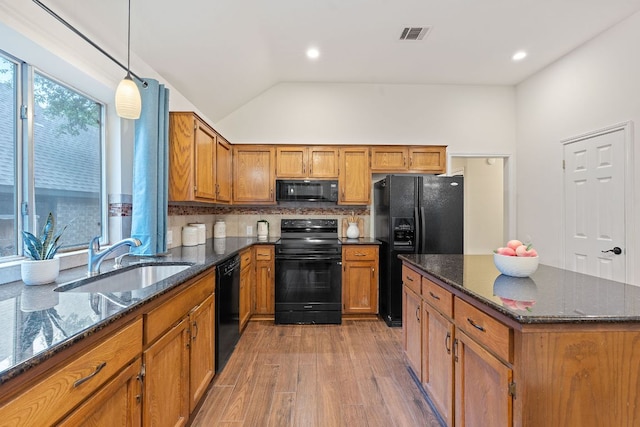 8104 Isaac Pryor Dr, Austin, TX 78749 - kitchen featuring a sink, brown cabinetry, black appliances, light wood-style flooring, and visible vents