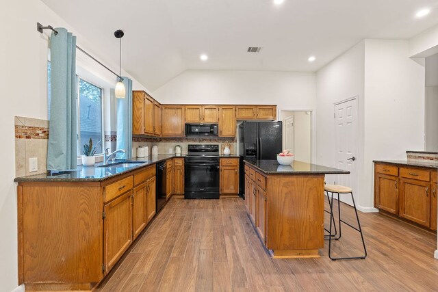 8104 Isaac Pryor Dr, Austin, TX 78749 - kitchen with brown cabinetry, black appliances, a sink, and visible vents