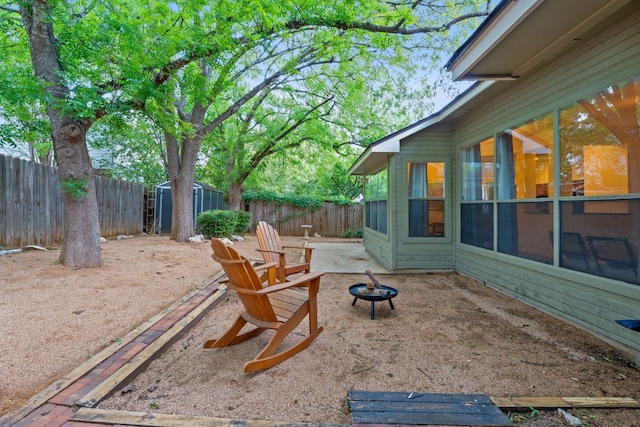 8104 Isaac Pryor Dr, Austin, TX 78749 - view of patio / terrace featuring a fenced backyard, a fire pit, a storage shed, and an outbuilding