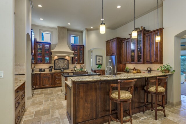 kitchen featuring stainless steel appliances, decorative backsplash, custom range hood, and crown molding