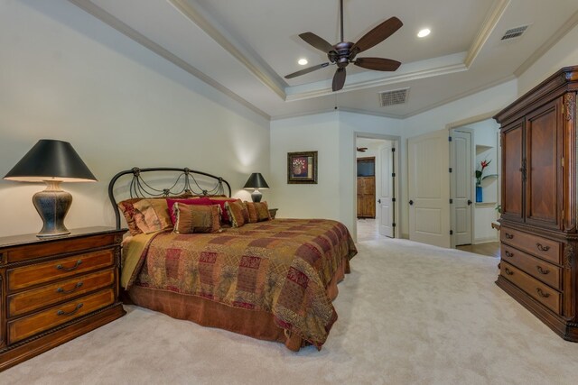 carpeted bedroom with ornamental molding, a tray ceiling, and visible vents