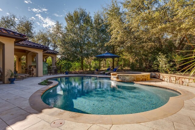 view of pool with a patio and a pool with connected hot tub