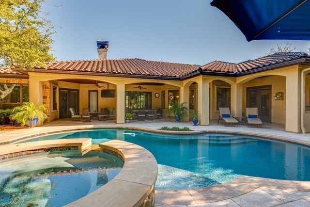 view of swimming pool featuring a patio area, a ceiling fan, and a pool with connected hot tub