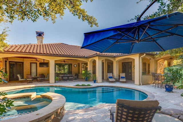 view of swimming pool with a patio, ceiling fan, outdoor dining space, and a pool with connected hot tub