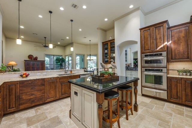 kitchen with a sink, a warming drawer, visible vents, stainless steel double oven, and crown molding