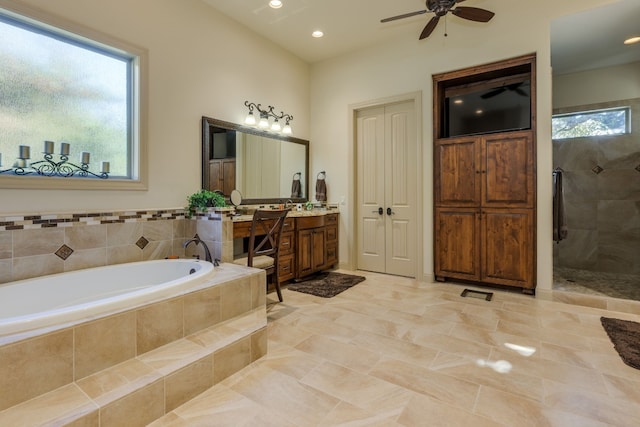 bathroom with a wealth of natural light, a garden tub, a ceiling fan, and a stall shower